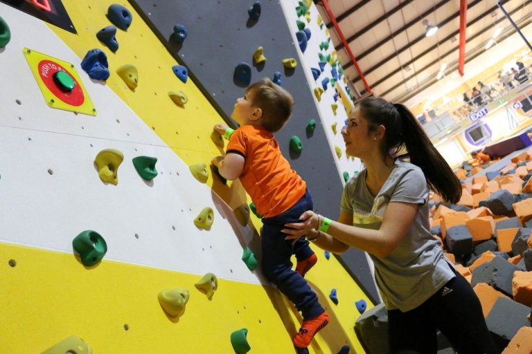 mother and son having fun on the climbing wall at itots ijump