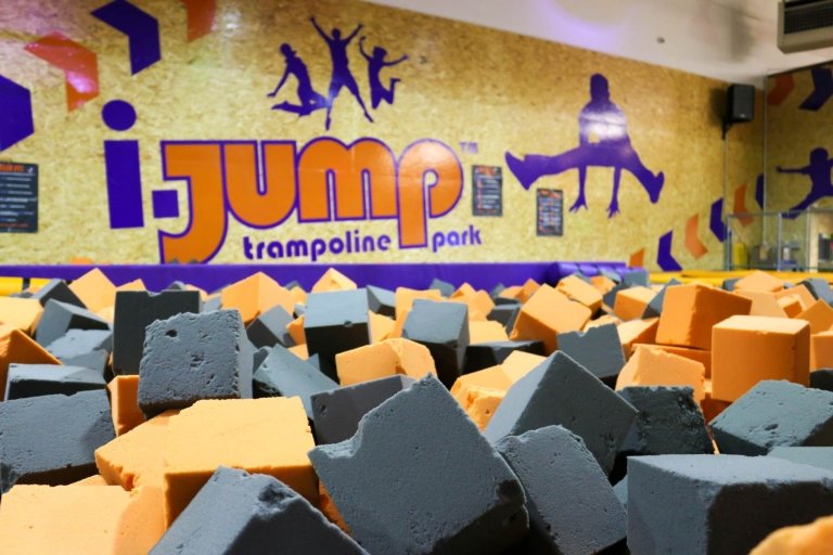 Our huge trampoline park foam pit with our logo on the wall in the background